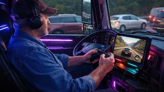 Trucker im Cockpit von Lkw beim Zocken