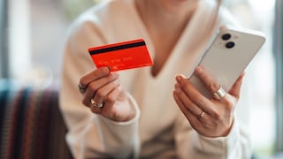 Frau mit Smartphone und Kreditkarte in Händen