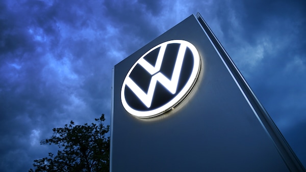 Das Volkswagen-Logo auf einer Steele vor dunklem Himmel.