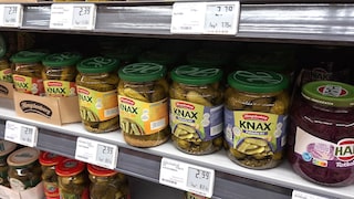 Gläser mit sauren Gurken im Supermarkt und mit digitalen Preisschildern
