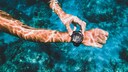 Person bedient eine Smartwatch unter Wasser