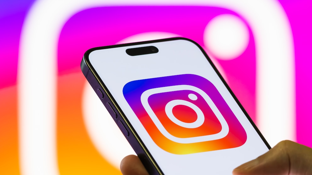 iPhone zeigt Instagram-Logo vor Hintergrund mit Instagram-Logo