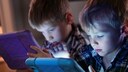 Kinder, die jeweils auf ein Tablet schauen
