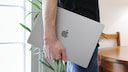 Mann tr&auml;gt MacBook unter dem Arm