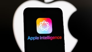 Smartphone mit dem Apple-Intelligence-Logo und Schriftzug. Im Hintergrund ist ein großes Apple-Logo auf schwarzem Hintergrund.