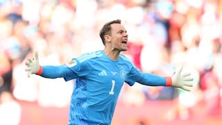 Manuel Neuer, in blauem Trikot, läuft jubelnd über ein Fußballfeld.