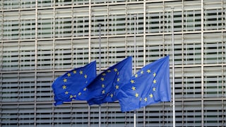 Drei wehende EU-Flaggen vor dem Parlamentsgebäude.
