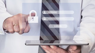 Mann mit Tablet in der Hand und einem virtuellen Fenster mit Passworteingabefeldern.