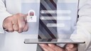 Mann mit Tablet in der Hand und einem virtuellen Fenster mit Passworteingabefeldern.