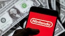 Smartphone mit Nintendo-Logo, im Hintergrund ein Stapel US-Dollar.