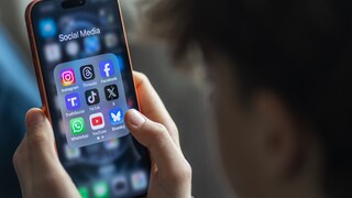 Teenager hält ein Smartphone auf dem viel Social Media-Apps zu sehen sind.
