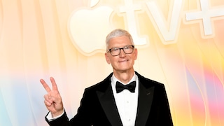 Apple's CEO Tim Cook vor gelb-rosa Hintergrund. Er zeigt das Peace-Zeichen.