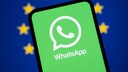 Smartphone mit WhatsApp-Logo im Vordergrund. Im Hintergrund die Europa-Flagge.