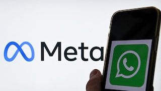 Smartphone mit WhatsApp-Logo im Vordergrund. Im Hintergrund das Meta-Logo.