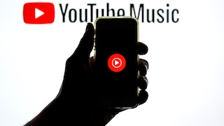 Smartphone zeigt YouTube-Music-Logo vor Hintergrund mit YouTube-Music-Schriftzug