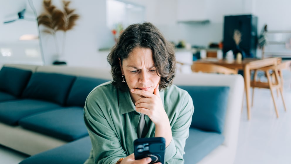 Frau mit iPhone in der Hand genervt