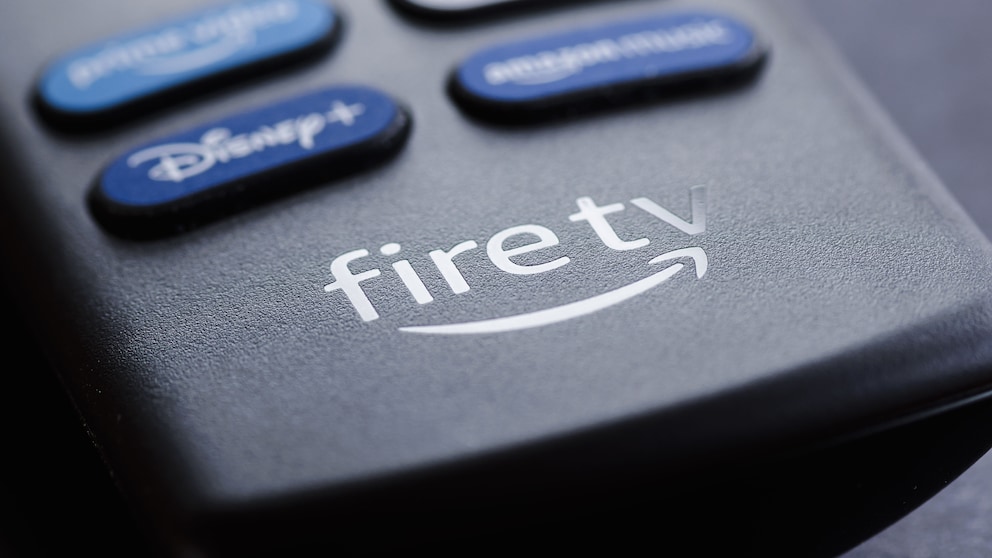 Nahaufnahme einer Fire-TV-Fernbedienung mit sichtbarem Fire-TV-Logo und mehreren unscharfen Tasten für Streamingdienste.