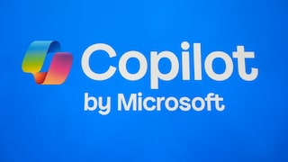 Alt-Text: Auf blauem Hintergrund ist das farbige Copilot-Logo neben dem weißen Schriftzug „Copilot“ zu sehen, darunter steht „by Microsoft“