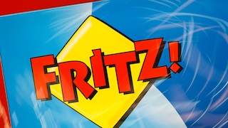 Das Bild zeigt das rote Fritz!-Logo auf gelbem, rautenförmigem Hintergrund. Dahinter sind blaue und hellblaue Flächen mit weißen Linien zu sehen.