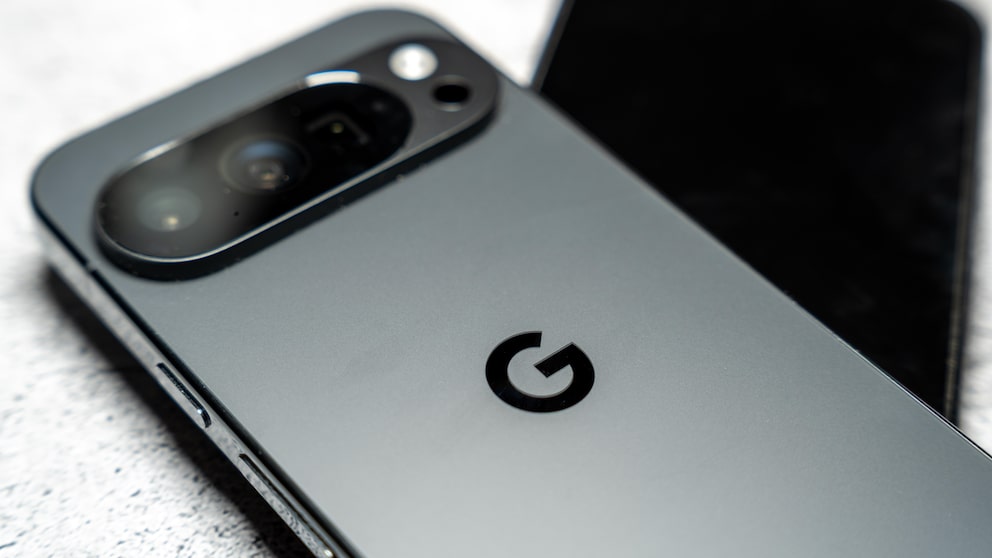 Alt-Text: Nahaufnahme eines grauen Google-Pixel-Smartphones mit sichtbarem Kameramodul und Google-Logo auf der Rückseite, daneben liegt ein weiteres unscharfes Smartphone im Hintergrund.