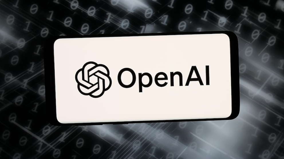 Ein Smartphone oder Display zeigt auf hellem Hintergrund das OpenAI-Logo und den Schriftzug „OpenAI“. Im Hintergrund sind unscharfe Reihen aus Nullen und Einsen sowie helle Lichtstreifen auf dunklem Grund zu sehen. Die Darstellung wirkt wie eine grafische Illustration zu den Themen Künstliche Intelligenz, Software und Cybersicherheit.