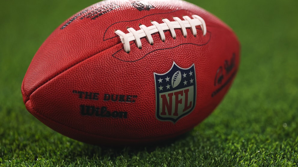 Das Bild zeigt einen American-Football mit gut sichtbarem NFL-Logo auf einem Rasenplatz. Der Ball liegt im Vordergrund, während der Hintergrund unscharf gehalten ist. Damit passt das Motiv thematisch zu einem Artikel über die neuen TV-Rechte der NFL.