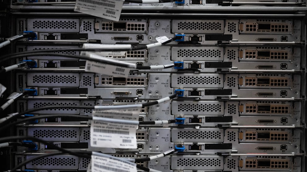 Rückseiten mehrerer gestapelter Server in einem Rechenzentrum mit angeschlossenen Netzwerkkabeln und Anschlussports in den Server-Racks.