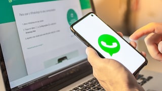 WhatsApp-Logo auf Smartphone vor WhatsApp Web auf Laptop