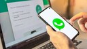 WhatsApp-Logo auf Smartphone vor WhatsApp Web auf Laptop