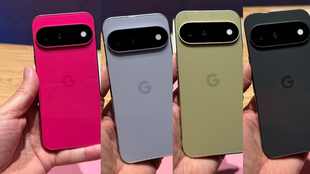Four Google Pixel 11 smartphones are held side by side by hands. The backs are visible in pink, light gray, light green, and dark gray. At the top, there is a black, horizontally aligned camera module with multiple camera openings and a flash. The devices are photographed against a blurred background.