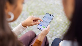 Frauen schauen auf iPhone mit Karten-App