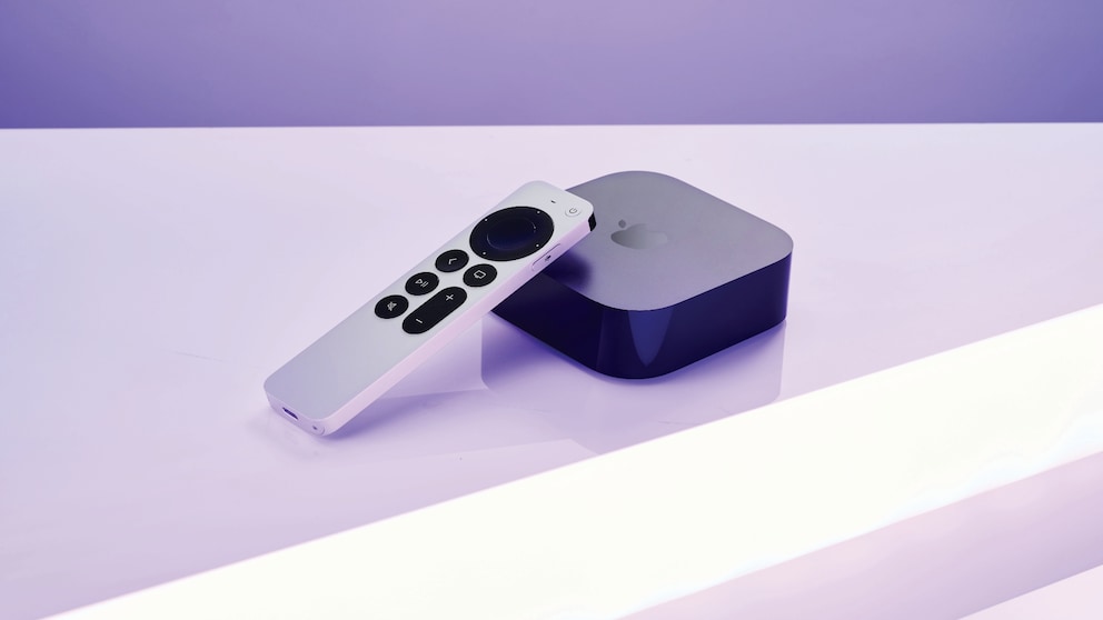 Apple TV und Fernbedienung liegen auf einer hellen Oberfläche