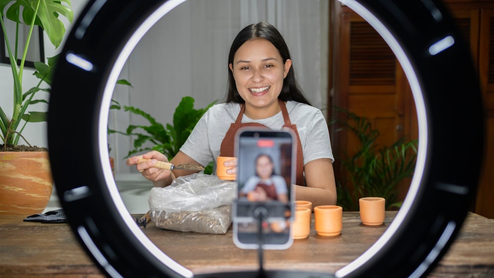 Junge Frau spricht in ihr filmendes Smartphone