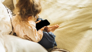 Kleinkind hält Smartphone in den Händen