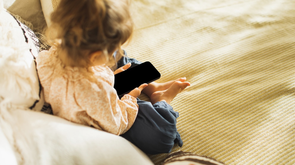 Kleinkind hält Smartphone in den Händen