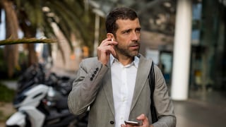 Geschäftsmann mit Smartphone und Earbuds