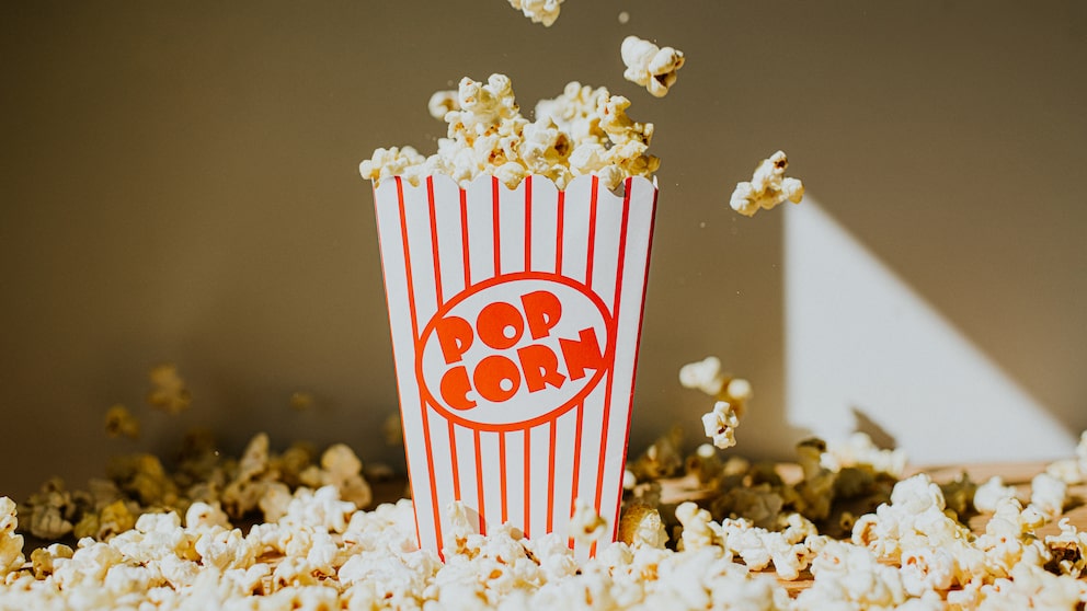 Popcorn-Becher umringt von ganz viel Popcorn