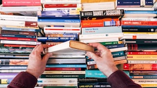 Person wühlt sich durch mehrere Bücher