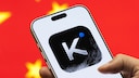 Logo der chinesischen KI-App Kimi auf einem Smartphone, dahinter die chinesische Flagge