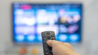 Person richtet Fernbedienung auf TV