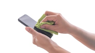 Frau wischt Smartphone mit Tuch ab