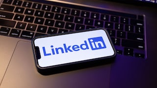 Ein iPhone mit dem LinkedIn-Logo auf dem Displa liegt auf einer Macbook-Tastatur