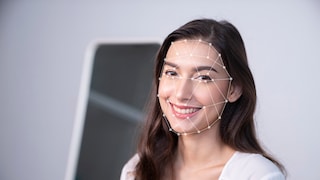 Eine Dame lächelt in die Kamera, dabei wird ihr Gesicht gescannt