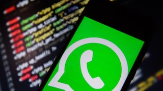 Smartphone mit WhatsApp-Logo vor IT-Code
