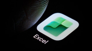 Nahaufnahme eines Smartphone-Displays mit der Excel-App. Das grün-weiße Excel-Logo ist vor schwarzem Hintergrund zu sehen. Links daneben befindet sich ein Finger, der kurz vor der App steht oder sie berührt. Unter dem Symbol steht der Schriftzug „Excel“.