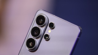 Nahaufnahme der Rückseite eines silberfarbenen Samsung-Smartphones mit mehreren Kameralinsen vor unscharfem blau-violettem Hintergrund