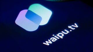 Nahaufnahme des waipu.tv-Logos auf einem dunklen Bildschirm. Zu sehen ist das App-Symbol mit zwei überlappenden, abgerundeten Rechtecken in Weiß, Hellblau und Violett sowie der Schriftzug „waipu.tv“.