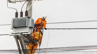 Arbeiter reparieren einen Strommast