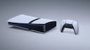 Wei&szlig;e PlayStation-Spielkonsole mit schwarzem Mittelteil auf hellem, neutralem Hintergrund. Rechts daneben steht ein wei&szlig;-schwarzer Controller. Die Konsole liegt waagerecht und zeigt an der Vorderseite mehrere Anschl&uuml;sse. Entlang der Geh&auml;usekante ist ein schmaler blauer Lichtstreifen sichtbar.