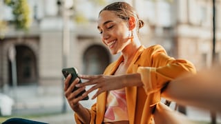 Frau nutzt ihr Smartphone und lächelt